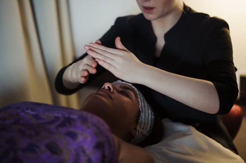 Complementary therapy student at Highlands College with a client lying down, with hands positioned above the body.