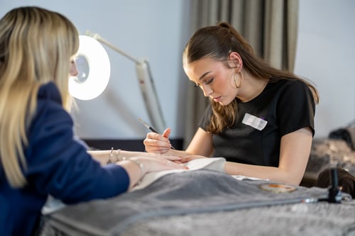 Beauty therapy student at Highlands College performing a manicure under task lighting during practical salon training.
