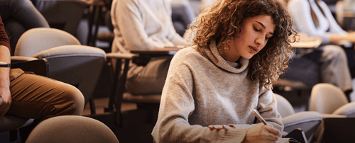 Student in a Classroom Taking Notes
